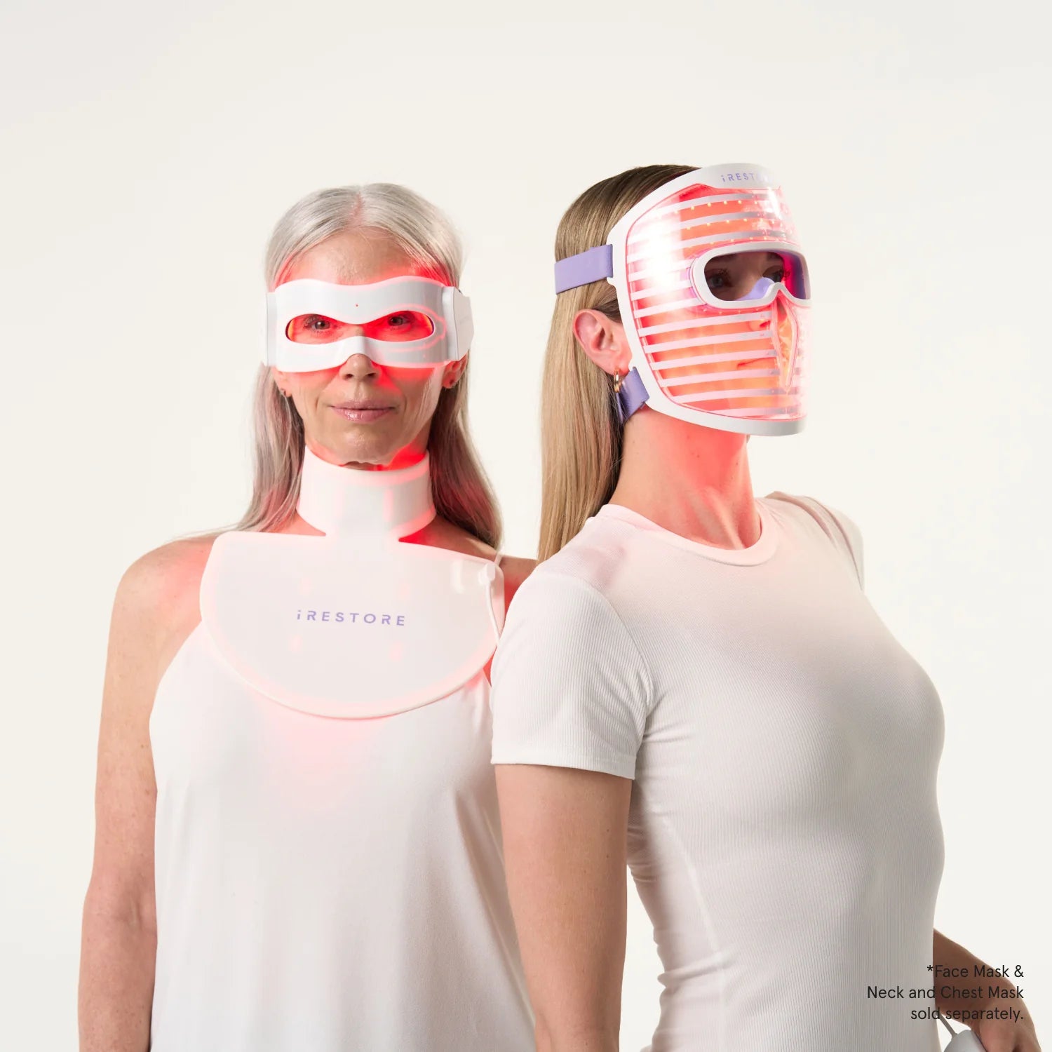 Woman wearing the LED eye mask while wearing the LED neck and chest mask standing beside woman wearing the LED face mask