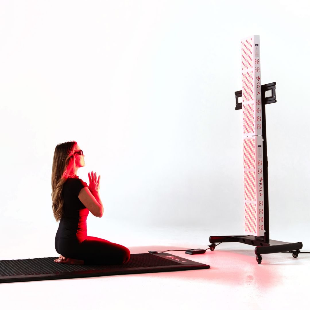 Woman in a yoga pose on a mat with a tall, cylindrical exercise device in the background.